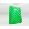 Shopper in plastica HDPE verde con fantasia "Pois" bianchi, maniglia fustellata a fagiolo, confezione da 5 kg.