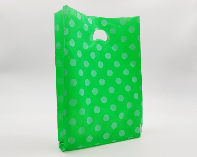 Shopper in plastica HDPE verde con fantasia "Pois" bianchi, maniglia fustellata a fagiolo, confezione da 5 kg.