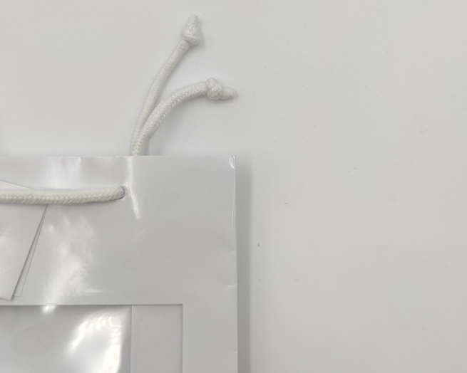 Shopper bianco in carta plastificata opaca, con finestra, maniglia in cotone e tag