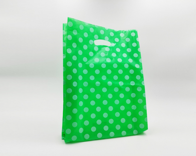 Shopper in plastica HDPE verde con fantasia "Pois" bianchi, maniglia fustellata a fagiolo, confezione da 5 kg.